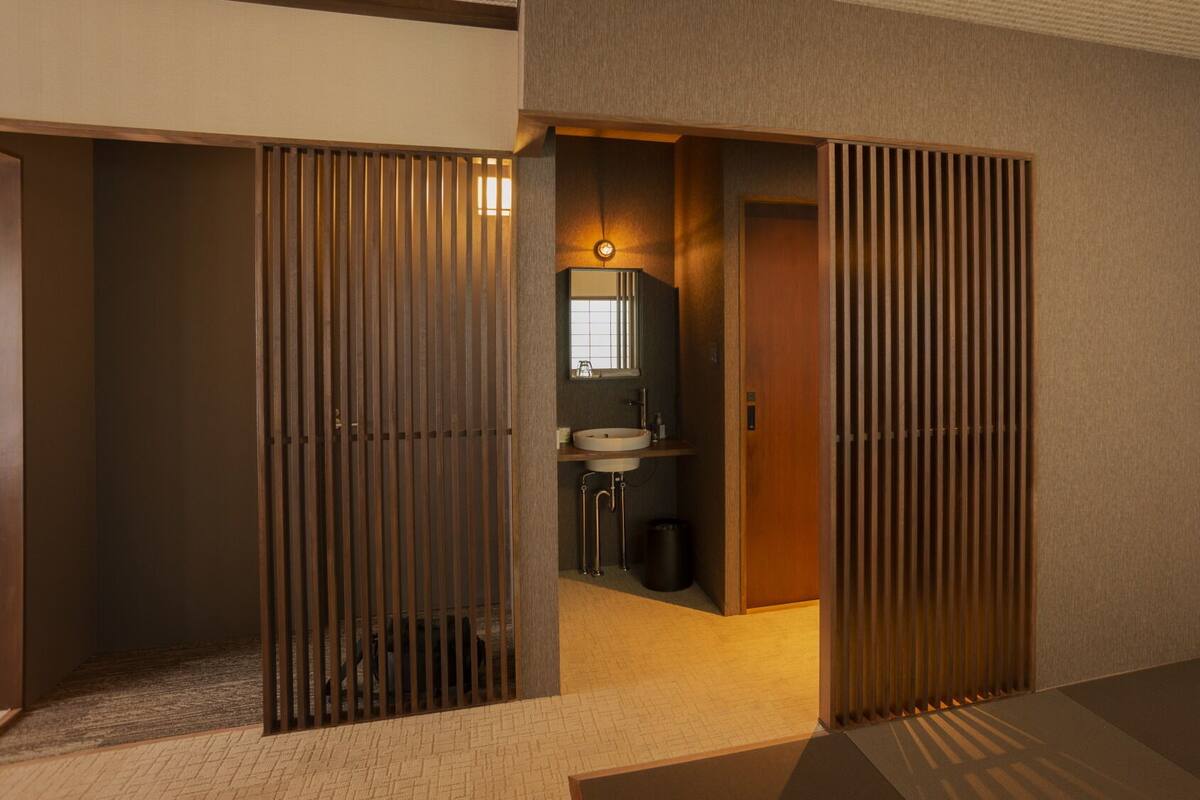 Un baño moderno con lavabo, espejo y puertas correderas de madera.