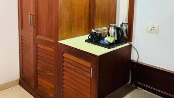 Un armario de madera con espejo y una encimera con artículos para preparar café.