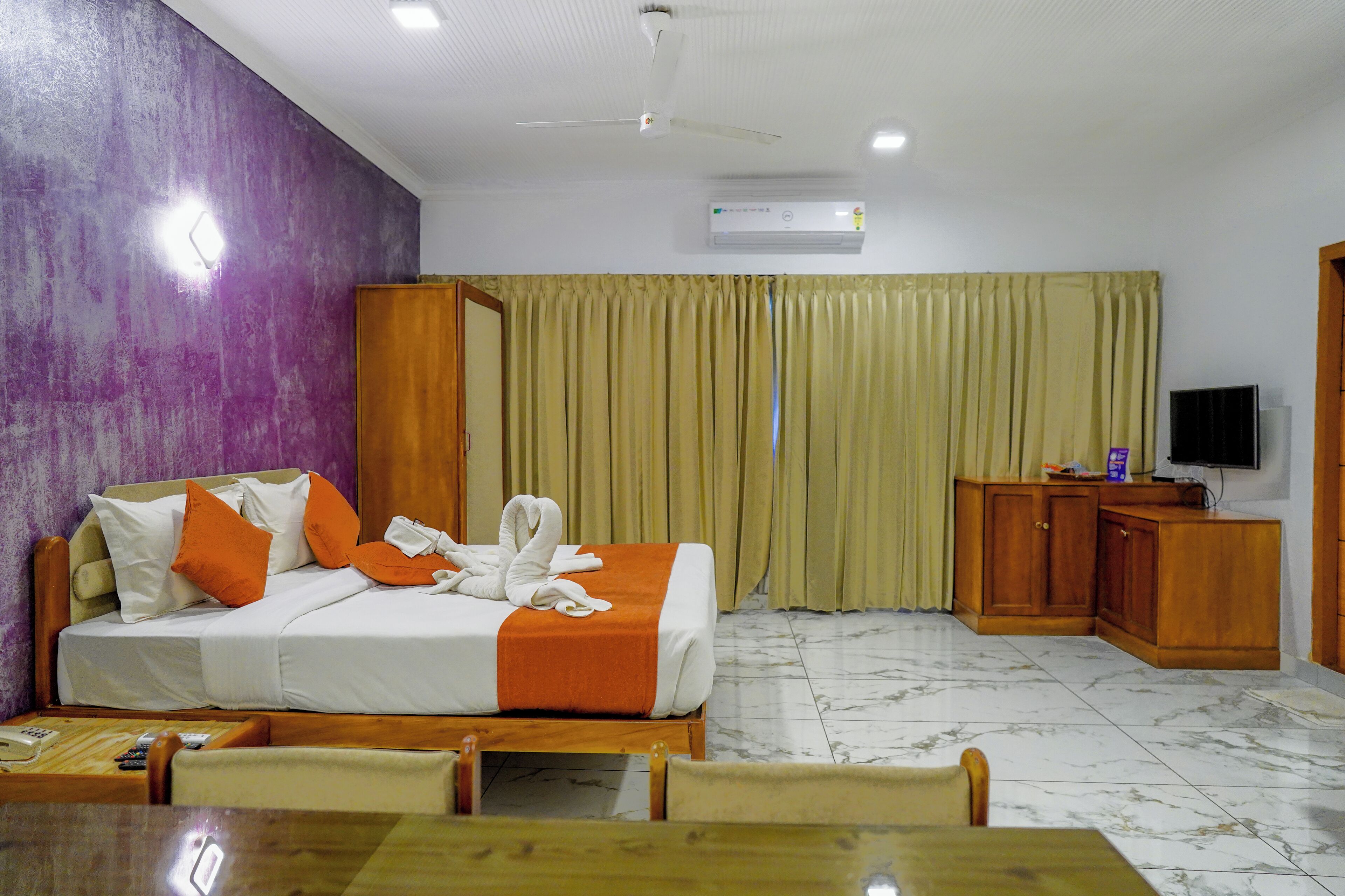Una habitación de hotel con cama, televisión, escritorio y una silla.