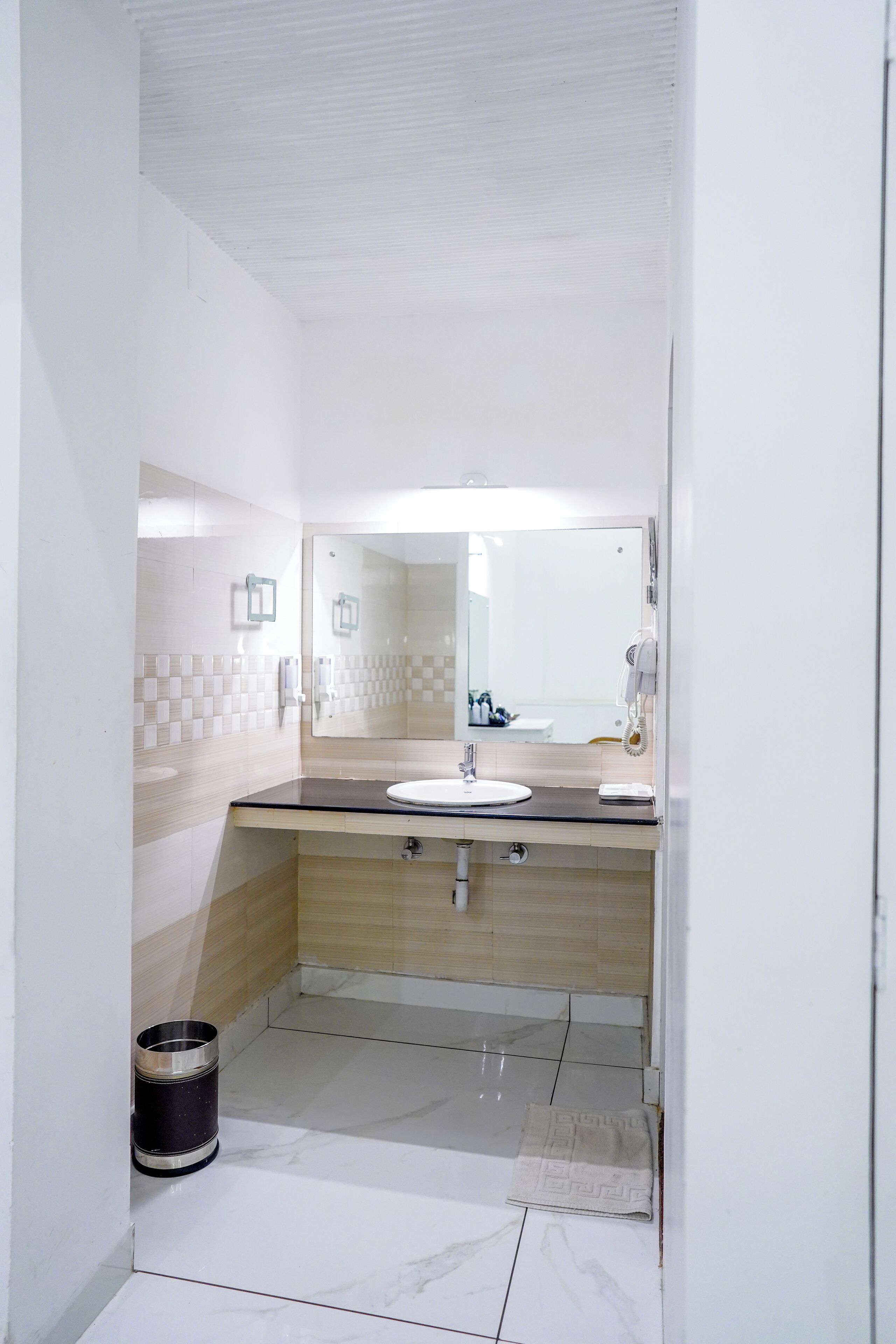 A bathroom with a sink, mirror, and toilet.