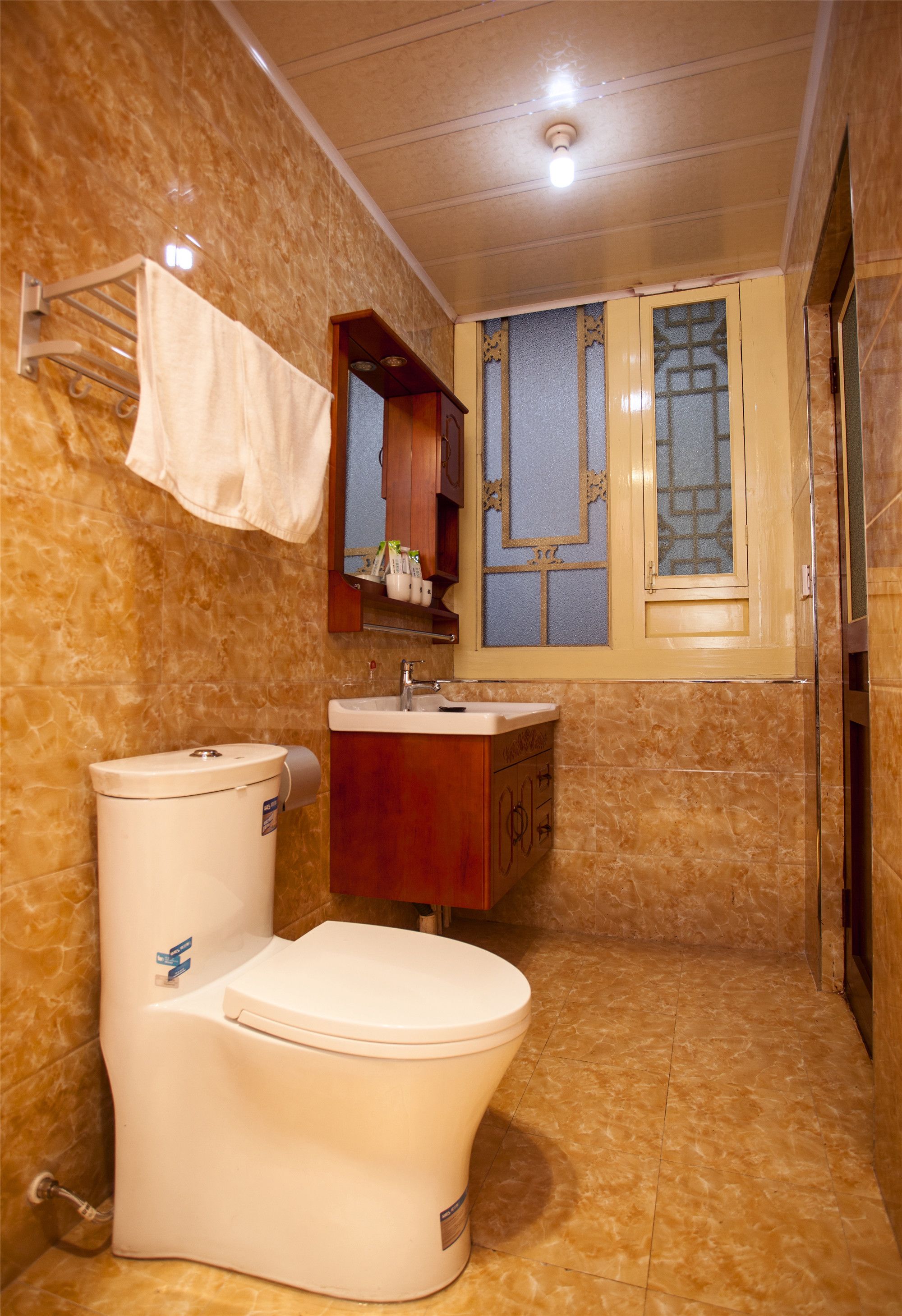 A bathroom with a toilet, sink, and mirror.