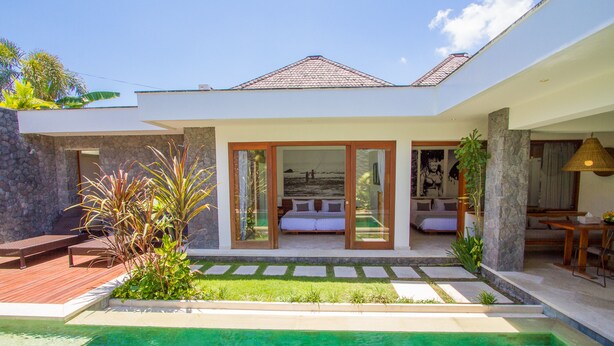 A modern house with a swimming pool, a patio with outdoor furniture, and a large glass door leading to a bedroom. - Villa Vishuddha Ajna (Seminyak)