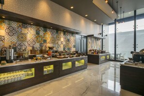 Una cocina moderna con salpicadero de azulejos, encimera de mármol y una variedad de electrodomésticos y utensilios de cocina.