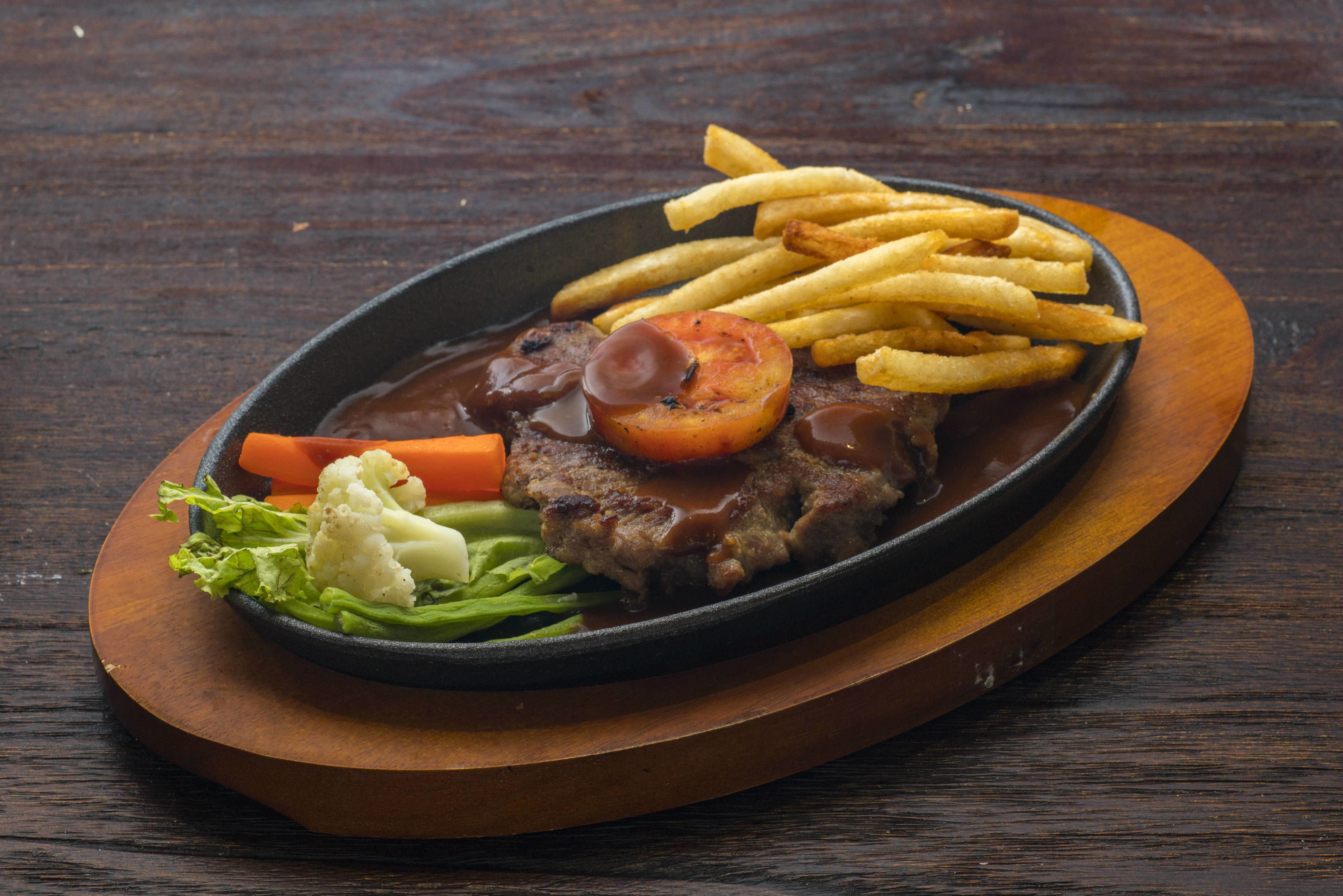 A plate of food with steak, fries, and vegetables.