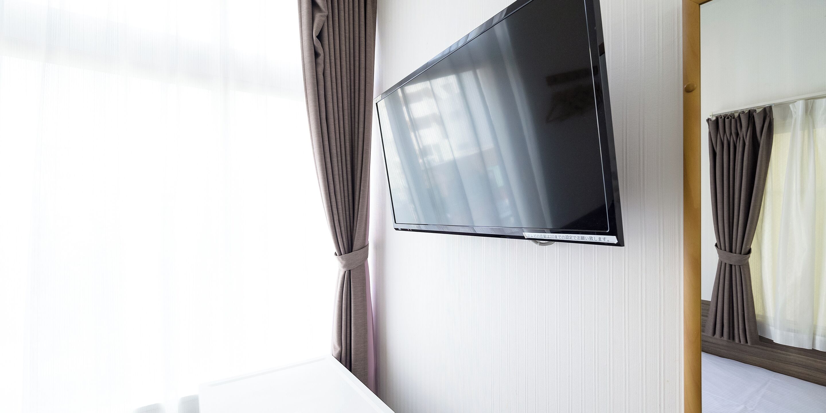 Ein Flachbildfernseher an der Wand in einem Hotelzimmer.