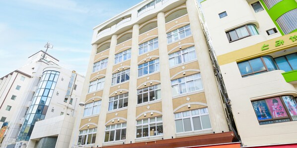 Un hôtel à plusieurs étages, doté d’une façade beige, de grandes fenêtres et d’une conception architecturale aux lignes courbes.