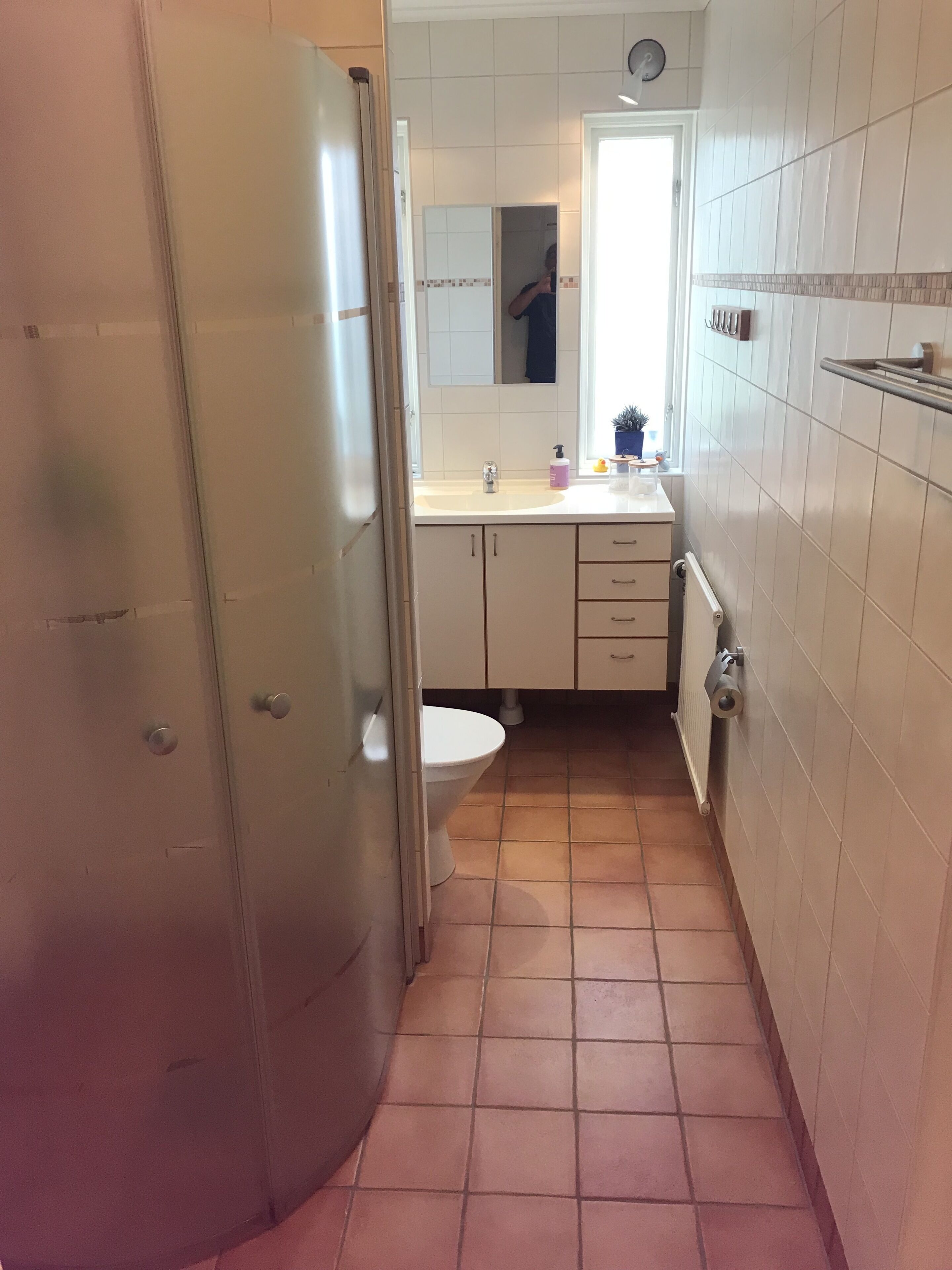 Een kleine badkamer met toilet, wastafel en spiegel.