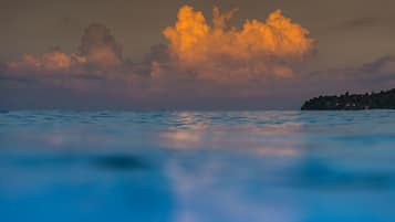 Mar tranquila con una costa distante y una gran formación de nubes.