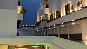 A modern building with a flat roof and multiple balconies. There are several windows and a few plants on the balconies. The building has a clean, white exterior. - Voga Motel (Taichung)