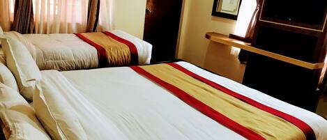 Habitación de hotel con dos camas, un televisor y una puerta con un letrero de ‘No Fumar'.