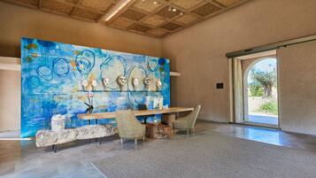 A modern interior with a large abstract painting, a reception desk, and a stone bench.