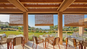 Un espace extérieur aménagé pour les repas, avec des tables et des chaises, offrant une vue sur un paysage pittoresque.