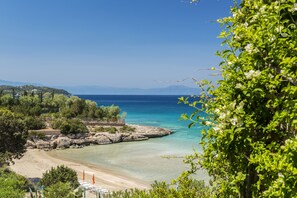 A coastal landscape with a beach, clear water, and rocky outcrops. - Electra Beachfront Villa (Ermionida)