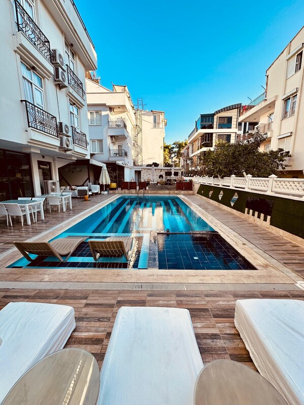 Alberca al aire libre y camastros