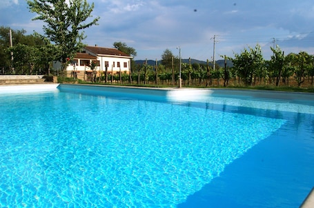 Una piscina al aire libre, sillones reclinables de piscina