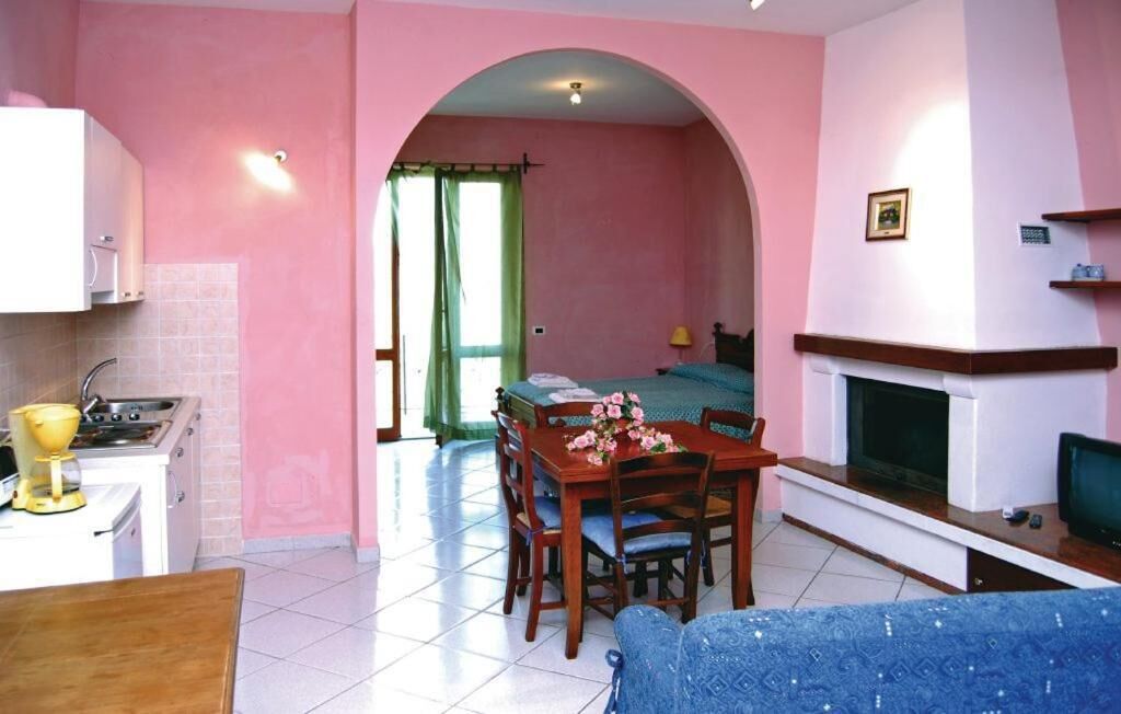 Un espacio habitable compacto con comedor, kitchenette y chimenea.