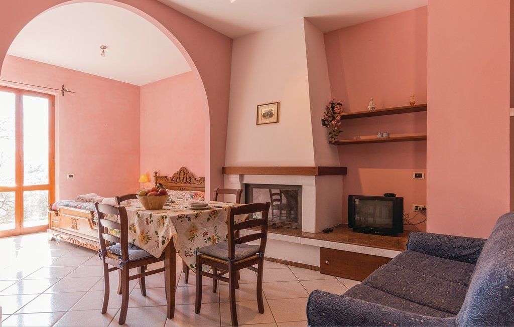Una sala de estar con comedor, chimenea y televisor.