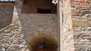 Un bâtiment en pierre avec une porte en bois et une entrée en arc de cercle.