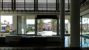 Un vestíbulo amplio con una zona de estar grande, entrada de vidrio y vistas al exterior.