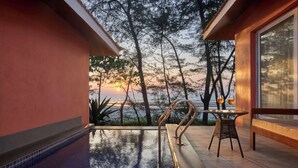 A pool area with a view of trees and the sunset. - Mandrem Beach Resort, a member of Radisson Individuals Retreat (Mandrem)