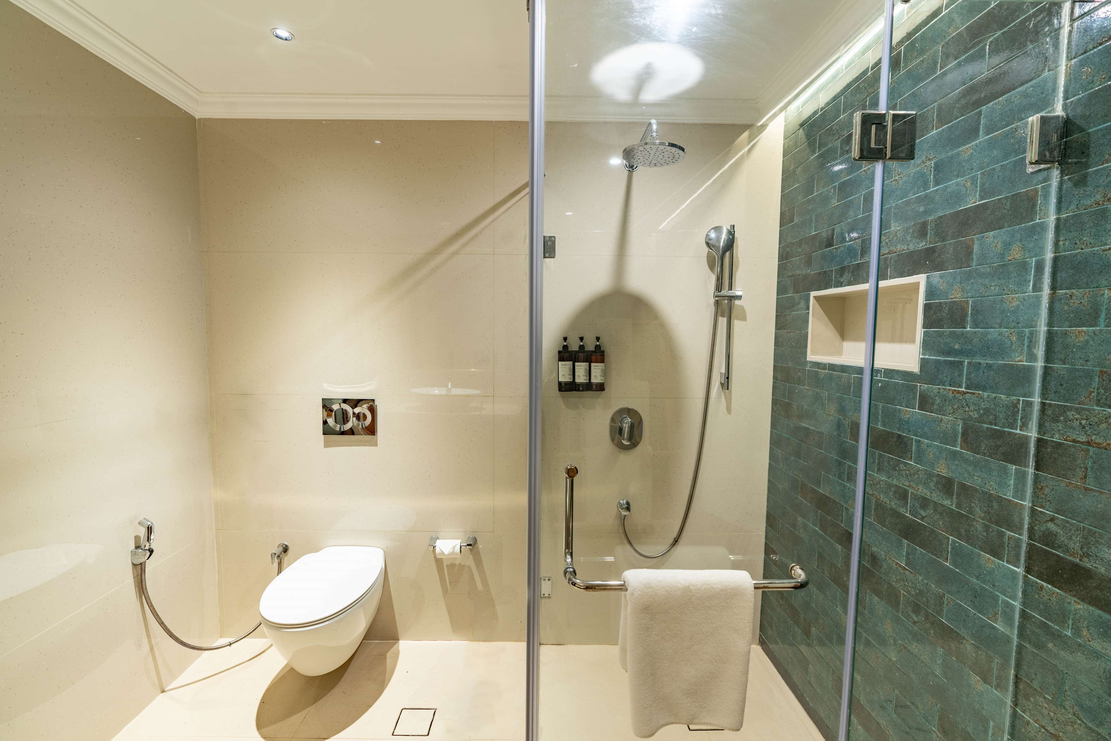 Un baño moderno con ducha de mampara, inodoro y toallero.