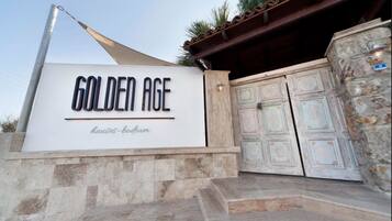 A sign for "Golden Age Houses - Bodrum" with a modern design and a traditional door.