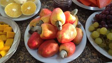 A variety of fruits including apples, oranges, and grapes on a granite countertop.