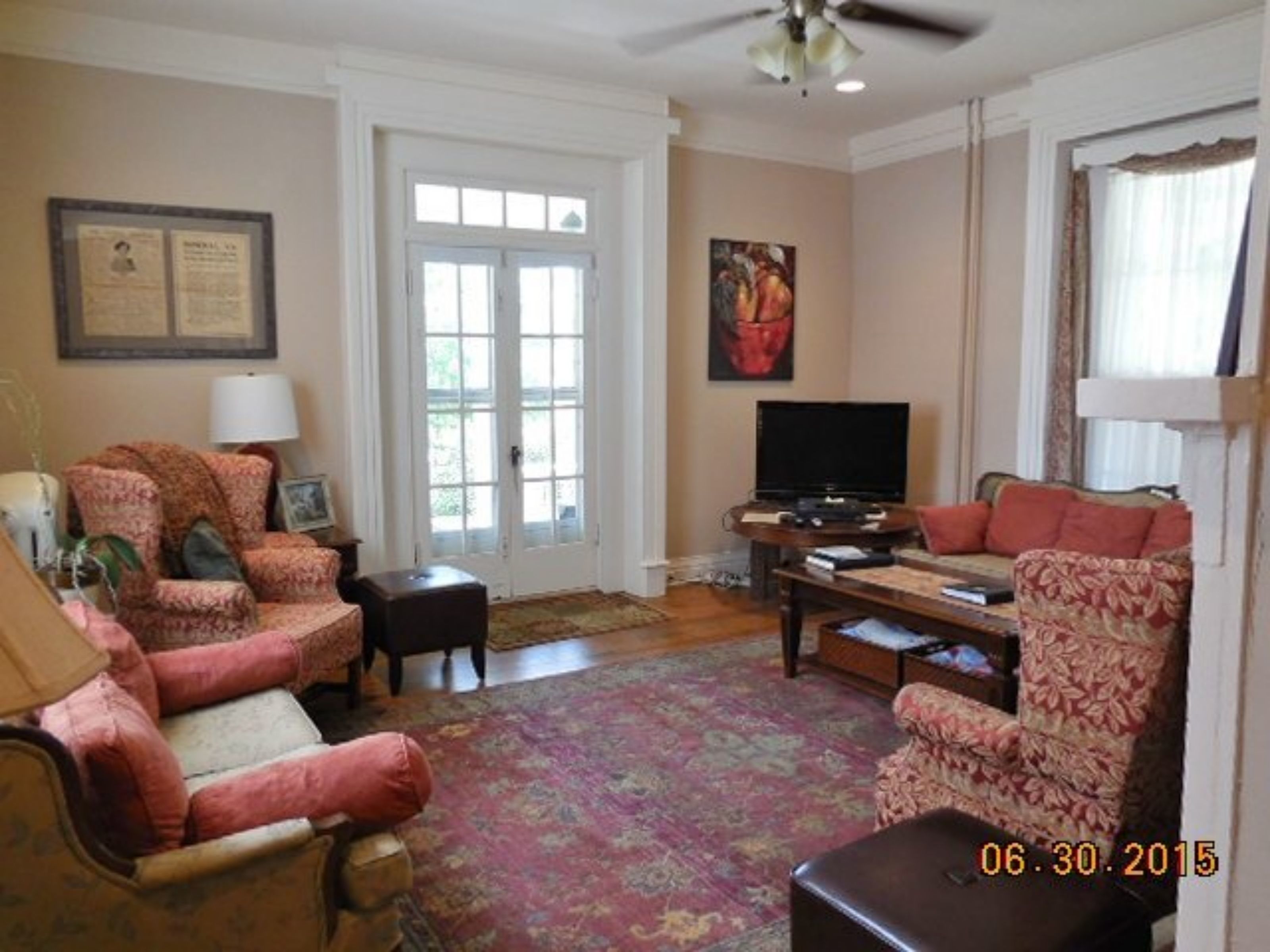 A living room with a fireplace, a television, and a large window.