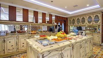 A buffet area with a variety of food items and a decorative mirror above the counter.