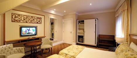 Une chambre d’hôtel équipée d’un lit, d’une télévision, d’un bureau et d’une armoire.