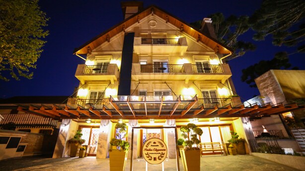 A multi-story hotel with a prominent entrance, balconies, and outdoor lighting. - Pousada Italia Eleganza (Campos do Jordão)
