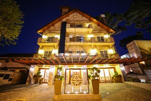 Vista frontal de la propiedad por la tarde o noche