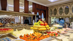 A buffet with various food items including fruits, vegetables, and desserts. - Pousada Italia Eleganza (Campos do Jordão)