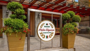 A hotel entrance with a sign reading "Fousada Itália Eleganza Campos de Jordão". - Pousada Italia Eleganza (Campos do Jordão)