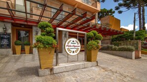 A hotel entrance with a sign reading "Povada Italia Eleganza." - Pousada Italia Eleganza (Campos do Jordão)