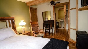Une chambre d’hôtel équipée d’un lit, d’un bureau, d’une chaise, d’un miroir, d’un lavabo et d’une cuisinière.