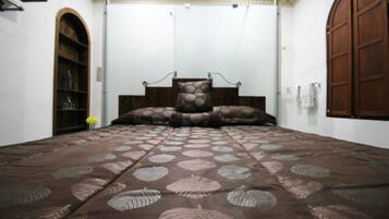 Un dormitorio con una cama, un armario de madera y un amplio arco de entrada.