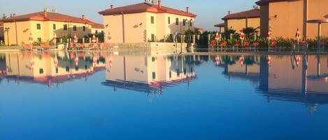 Una piscina al aire libre de temporada, sombrillas