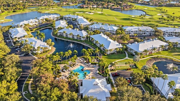 A golf course with multiple water bodies, a central swimming pool, and a resort area with white buildings and palm trees.