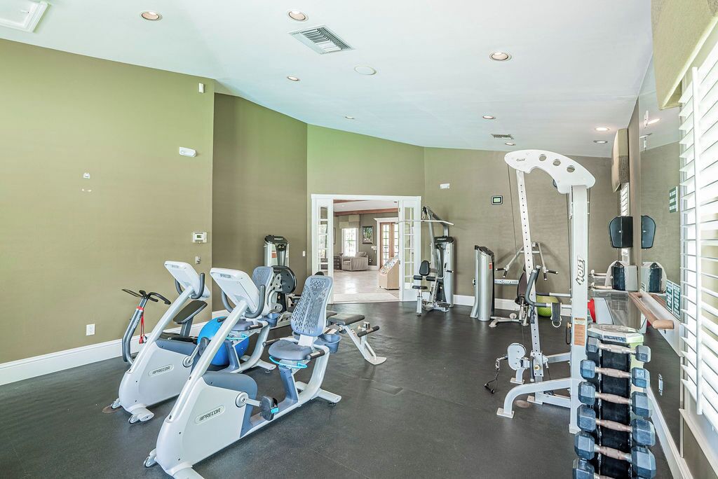 Et fitnesscenter med løbebånd, crosstrainere og styrkeudstyr.