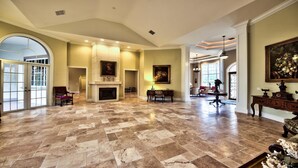 A spacious living room with a fireplace, a dining area, and a large window.