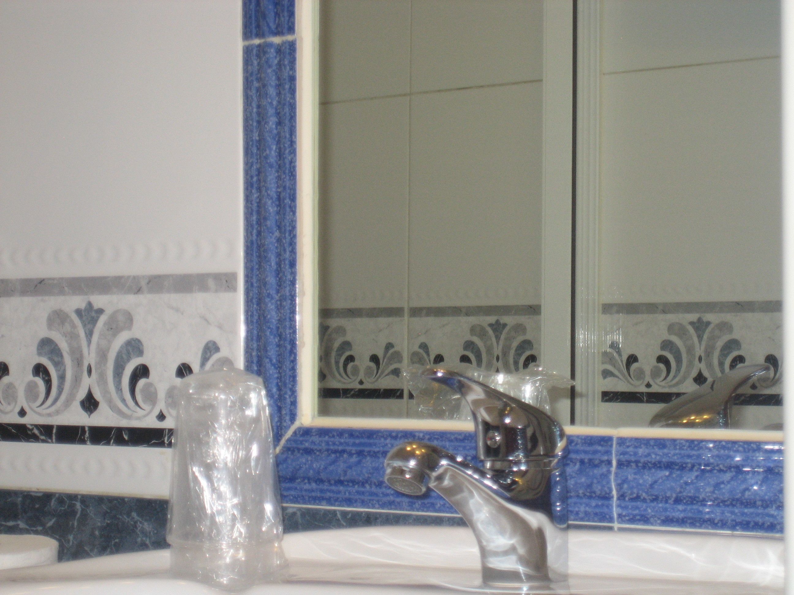 A bathroom with a sink, a faucet, and a mirror.