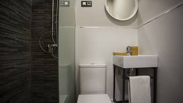 A modern bathroom with a glass-enclosed shower, a white sink, and a mirror.