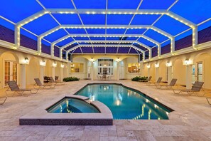 Ein Innenpool mit Glasdach, Liegestühlen und einer Terrassenanlage.