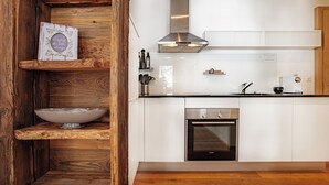 Een moderne keuken met witte kasten, een roestvrijstalen afzuigkap en een inbouwoven.