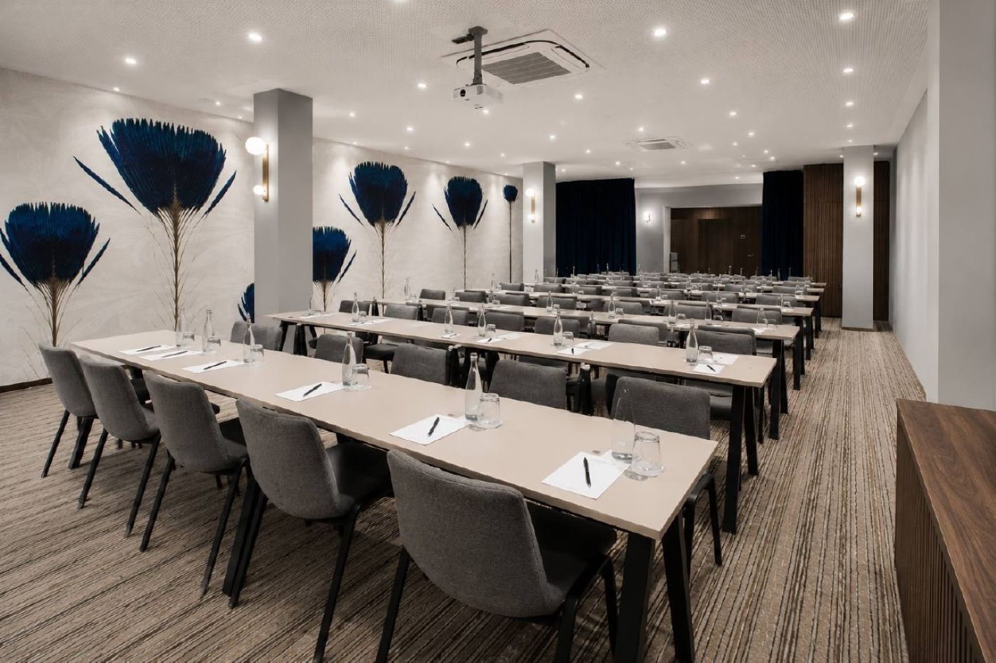 A conference room with long tables, chairs, and decorative wall art.
