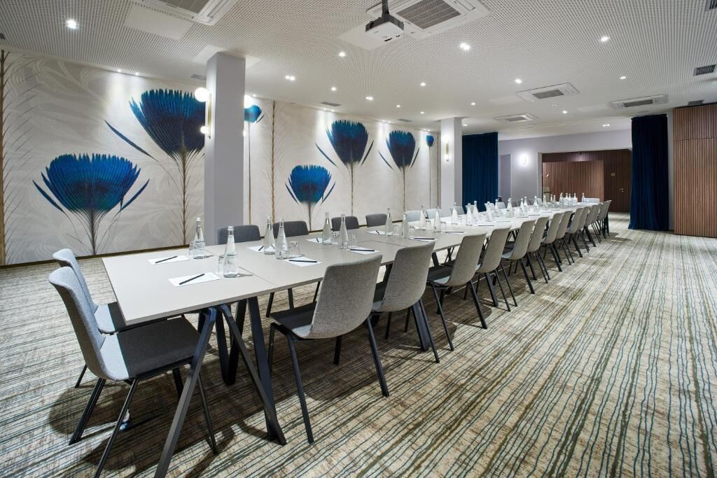 A conference room with a long table, chairs, and decorative wall panels.