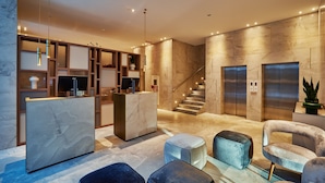 A modern lobby with a reception desk, seating area, and elevators. - Radisson Hotel City Centre Odesa (Odesa)