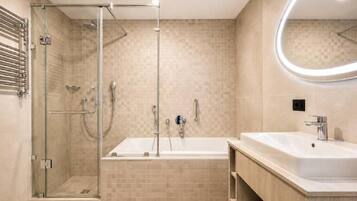 A modern bathroom with a glass-enclosed shower, a freestanding bathtub, and a vanity with a sink.