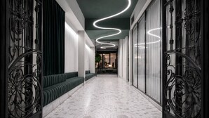 A hallway with a patterned floor, green seating, and ornate metal railings. - Radisson Hotel City Centre Odesa (Odesa)